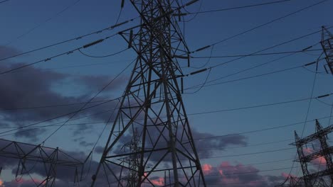 Amplia-Panorámica-E-Inclinación-Hasta-Torres-Eléctricas-Contra-El-Cielo-Al-Final-Del-Día