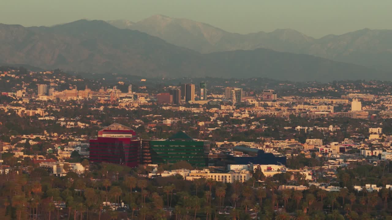Ripresa aerea in dolly con teleobiettivo del Pacific Design Center a Hollywood, vista da Beverly Hills al tramonto a Los Angeles, California. 4K