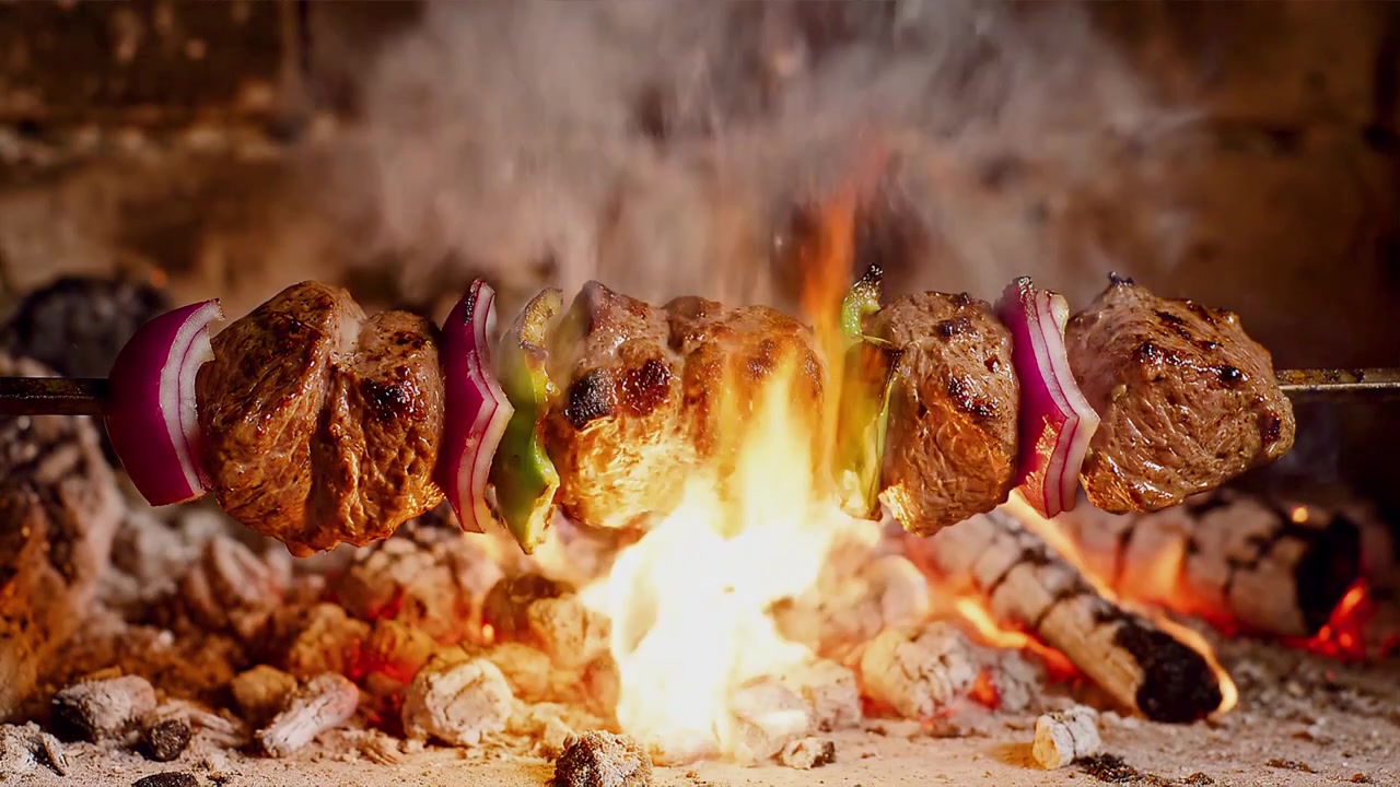 Deliziosi spiedini di carne e verdure che arrostiscono su braci ardenti