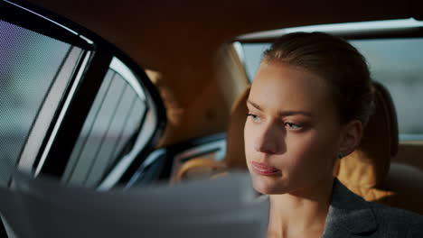 business woman looking financial papers in vehicle. woman reading documents