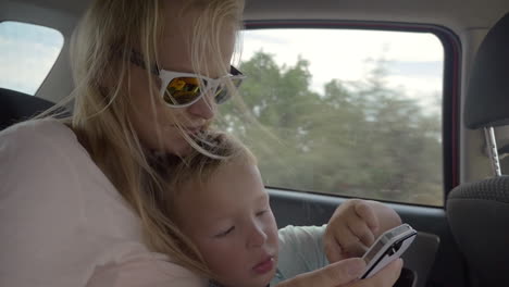 child playing with mothers smartphone in the car