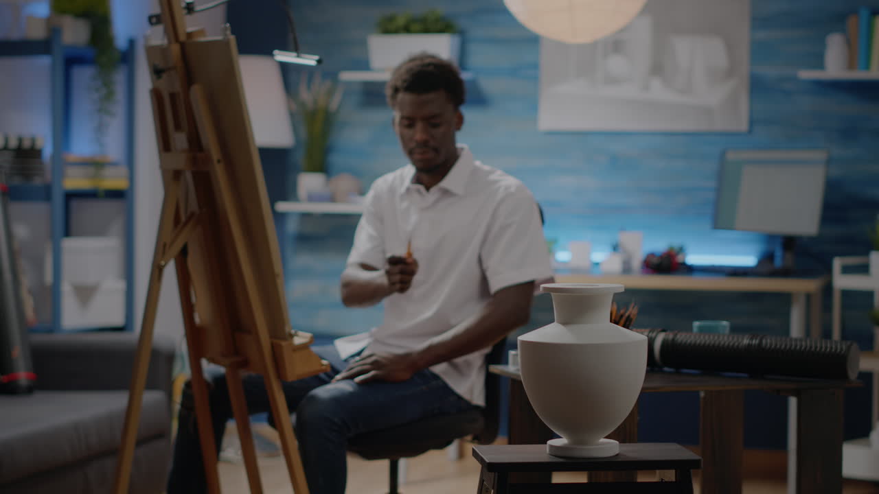 Black young man drawing vase for creative project