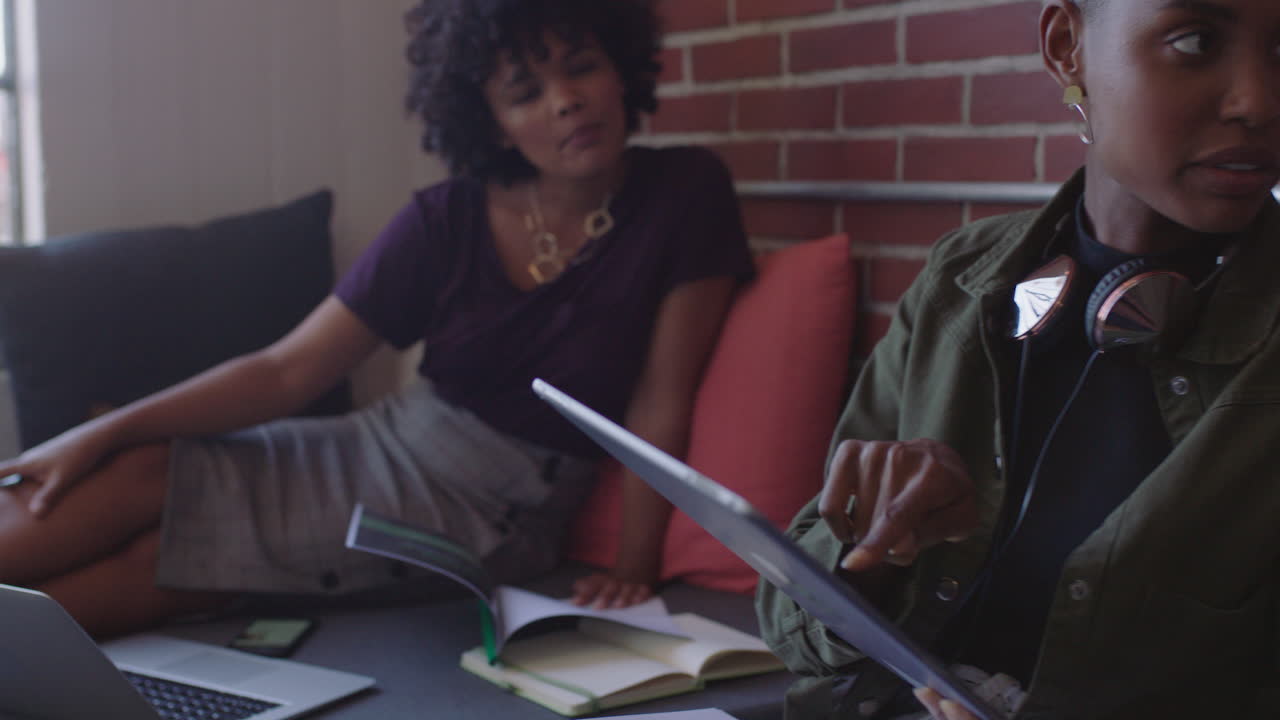 young black business people meeting brainstorming working together on corporate project sharing ideas using tablet technology in relaxed modern office workplace