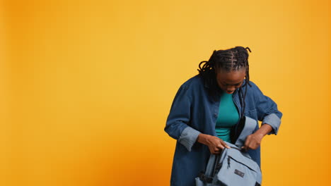 Portrait-of-happy-woman-rummaging-through-backpack,-looking-for-school-notebook