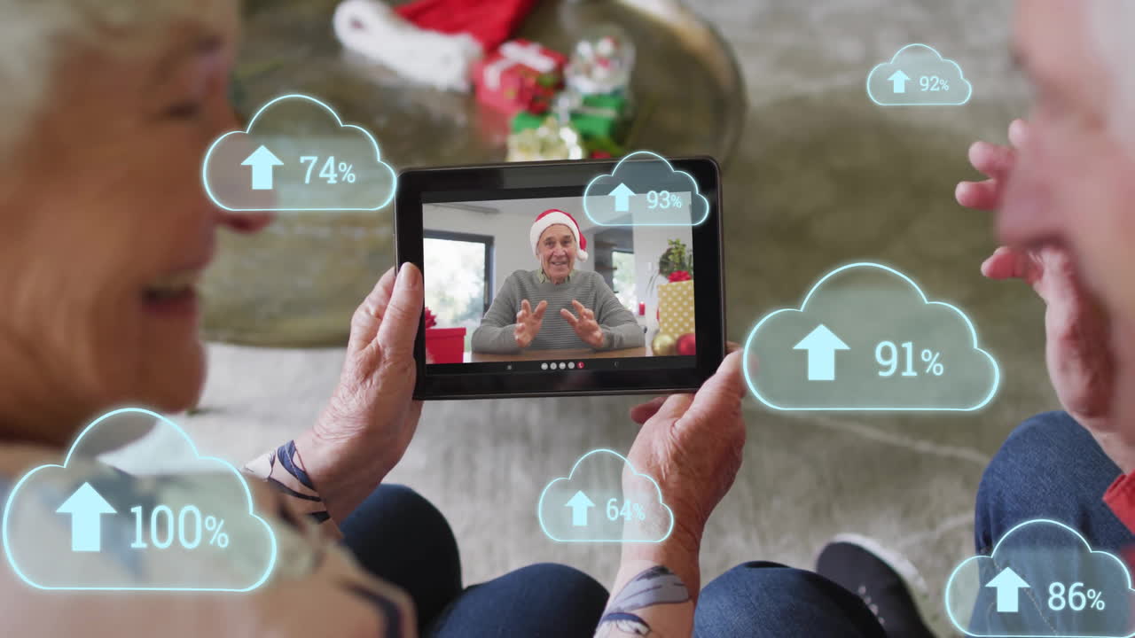 Senior couple holding tablet next to gift boxes, sharing technology call with floating upload icons