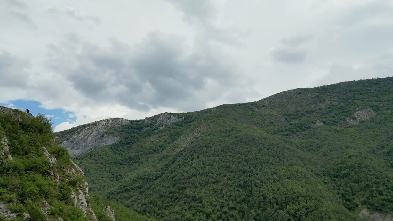 High-altitude view of a tranquil French mountain region, dotted with trees and wildflowers.