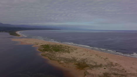 South-Africa-George-Mossel-Bay-Garden-Route-beach-aerial-drone-cinematic-holiday-vacation-town-Jeffreys-Bay-waves-crashing-aqua-blue-brown-ocean-late-morning-afternoon-cloudy-Africa-upward-movement