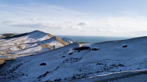 paisaje montañoso nevado con vistas al océano