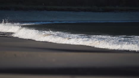 waves break slowly on the shallows of the sandy beach in ersfjord