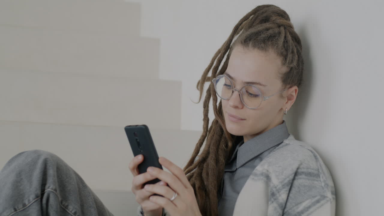 Young Woman Using Smartphone on Stairs