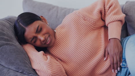 mujer, enferma y dolor menstrual en el sofá de casa