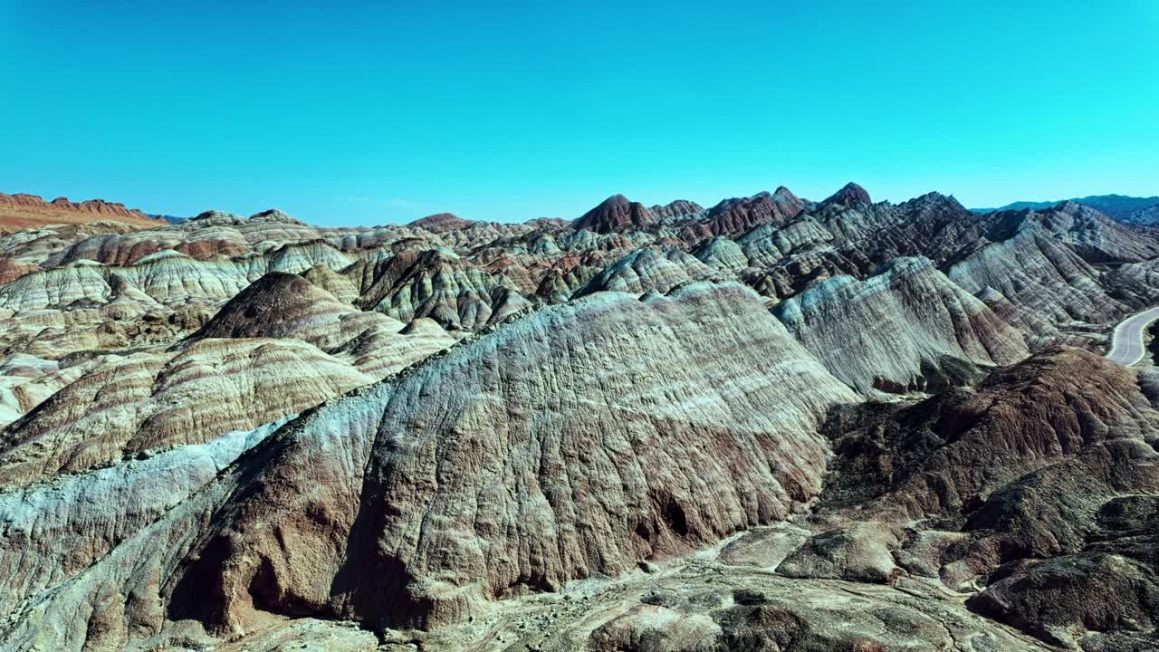 Zhangye, Gansu Province, China - The Hills Stretch Out in Soft, Colorful Layers, Blending Warm Reds and Pale Blues Under the Clear Sky - Pan Shot