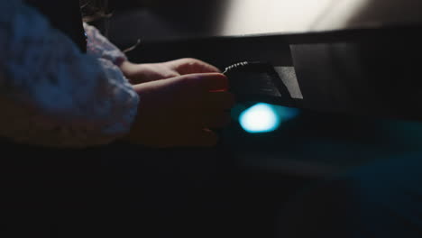 child yanks synthesizer cable in recording studio. petite girl uninterested in music lesson interacts with digital device wire. bored during studying