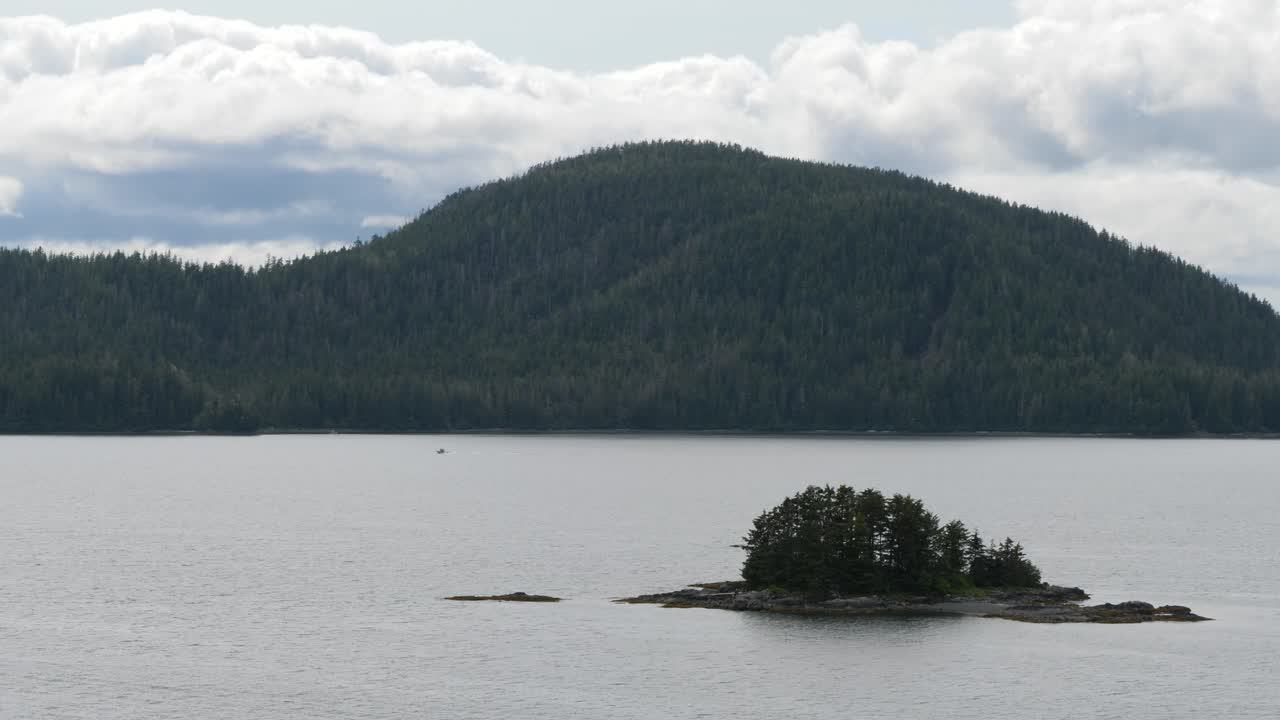 Sitka, Alaska small rocky island covered by pine trees.