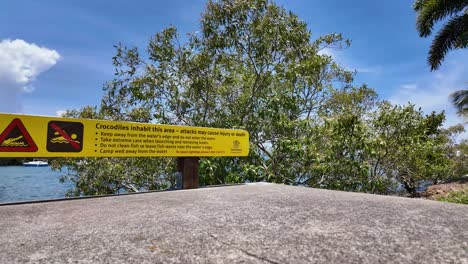 el norte de queensland, australia, es un signo de advertencia para la gente. los cocodrilos habitan la zona y los ataques pueden causar lesiones o la muerte.