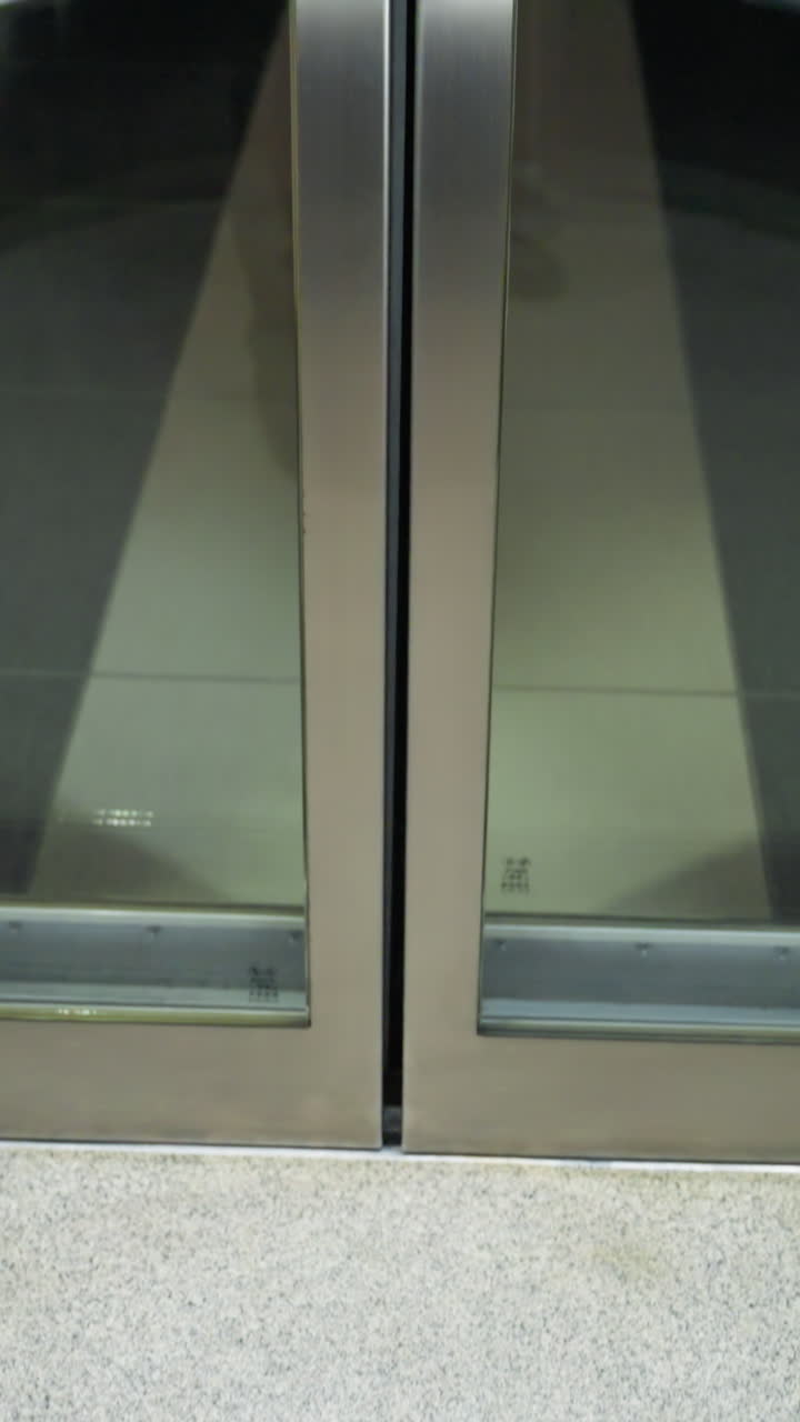 엘리베이터 문이 닫히는 순간을 포착하는 1인칭 관점. 이 이미지는 엘리베터 내부의 우아하고 현대적인 디자인을 보여주며 문 메커니즘과 바닥을 강조합니다.