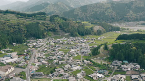 aerial view of village and lush tea farms between the green mountains in kawane, shizuoka, japan