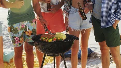 friends cooking food on barbecue and drinking beer at the beach 4k