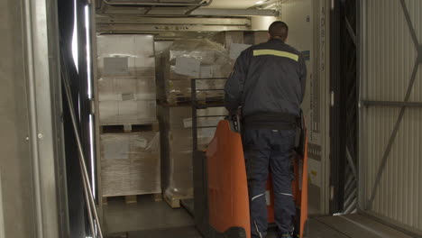 loader loading cargo pallet in packed truck trailer