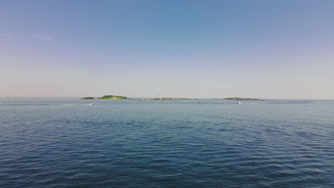 Aerial-footage-Two-Speedboats-crossing-in-front-of-Island-with-lighthouse