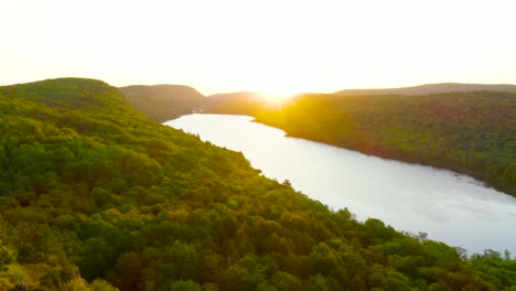 aerial pullback to reveal lake of the clouds in michigan's porcupine mountains during sunrise