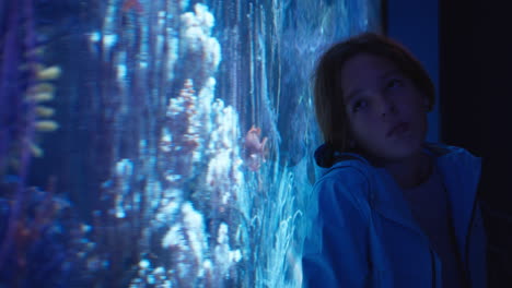 niño adolescente viendo el acuario en el oceanario
