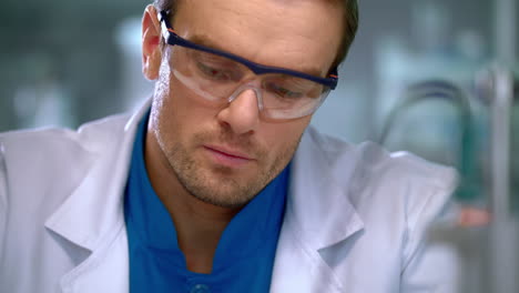 scientist writing down some data with pen. scientist hands making notes