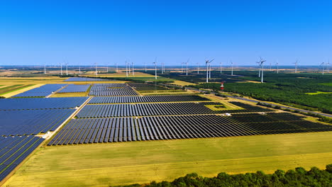 numerous solar panels gather sunlight in the fields. wind turbines produce green energy. aerial view