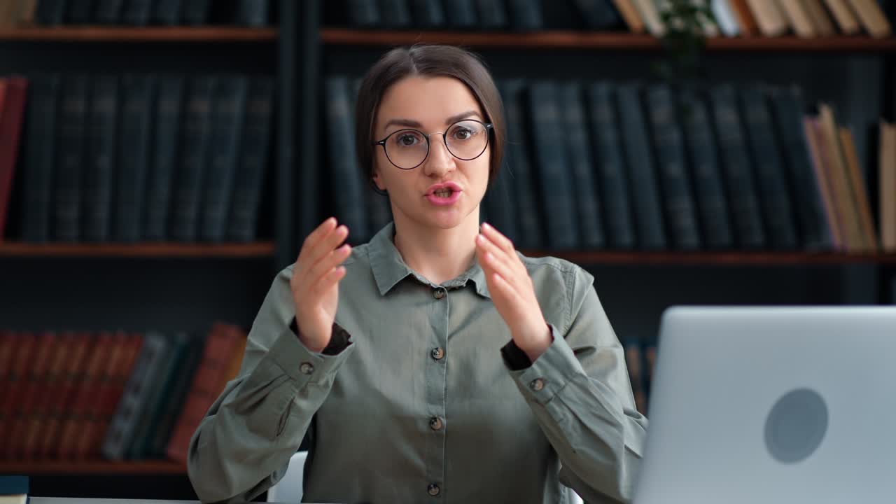 Confident woman librarian blogger talking books at vintage library communication shooting video