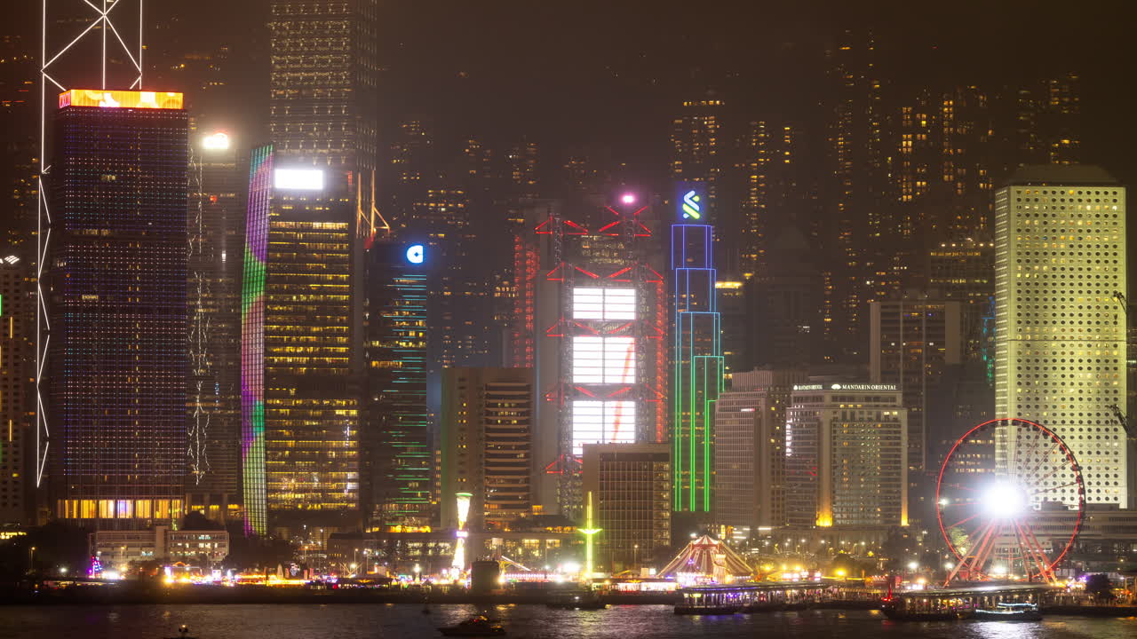HONG KONG - 19 MARCH 2025 : Hong Kong Central city skyline filmed from across the harbour in kowloon with all the skyscrapers lit up at night advertisements