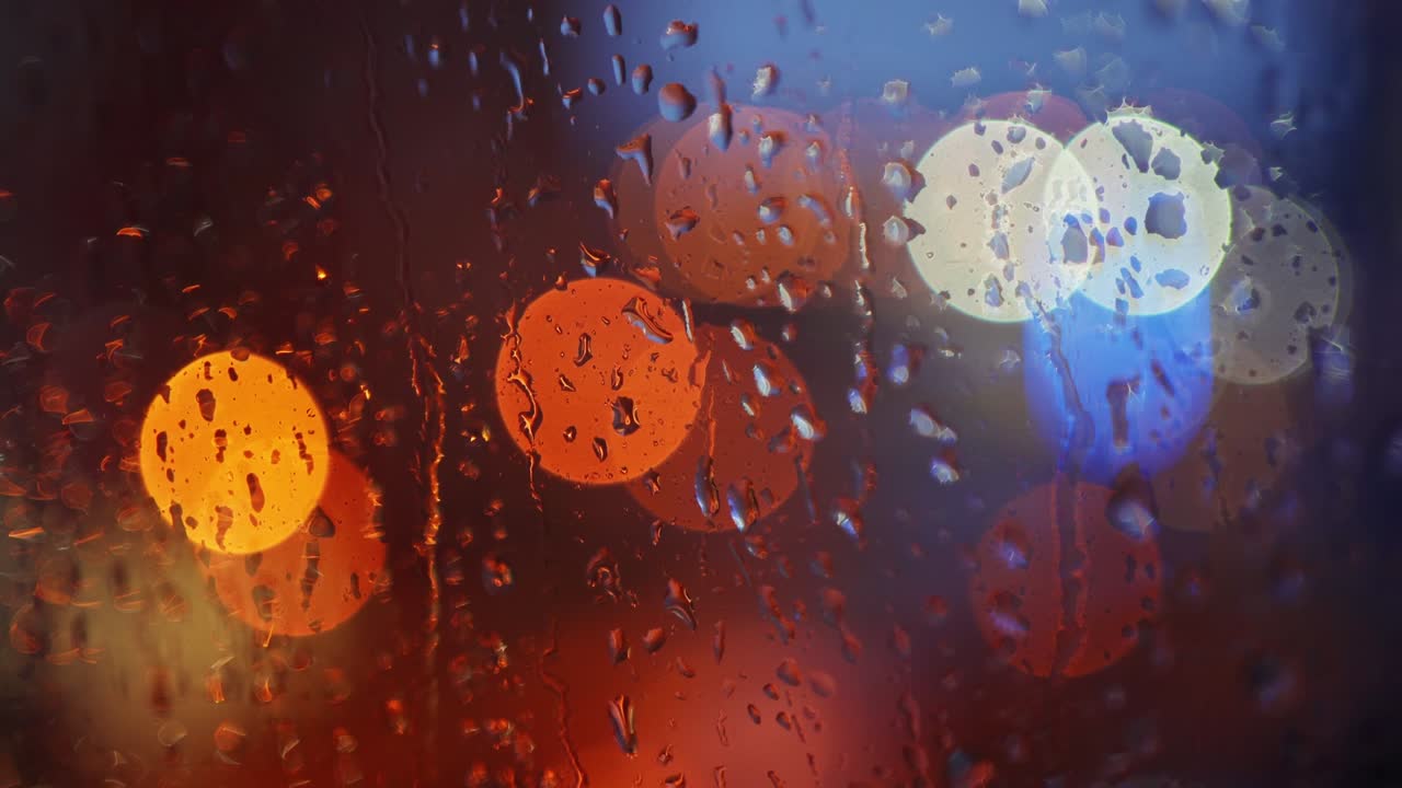 luces de la ciudad fuera de foco por la noche vistas a través de una ventana cubierta de gotas de lluvia durante la lluvia. macro de cerca.