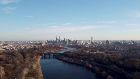 Un-Hermoso-Disparo-Aéreo-De-Drones,-Drones-Volando-Sobre-Un-Río-Moviéndose-Hacia-El-Horizonte-De-Rascacielos-De-Filadelfia,-Pennsylvania