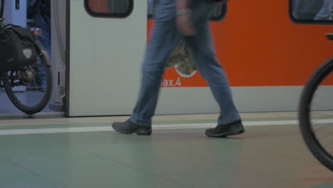 Vista-Inferior-De-Las-Piernas-De-Los-Pueblos-Que-Entran-Y-Salen-Del-Tren-En-La-Estación-De-Metro-Frankfurt-Am-Main-Alemania