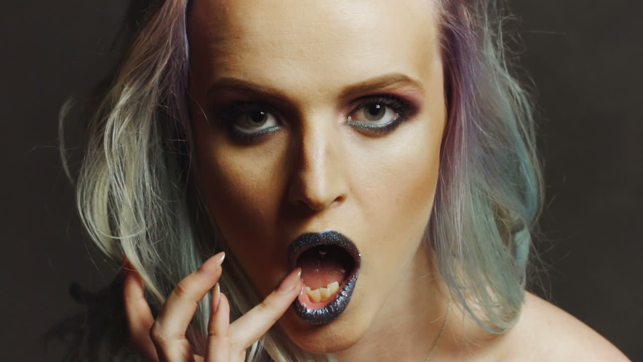 Colourful Studio Shot of Funny Model Girl. Beauty woman portrait with colorful makeup and hair