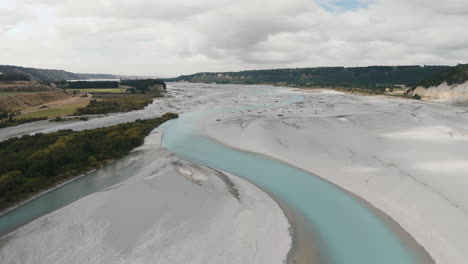aerial view of a turquoise river and dry riverbed in new zealand