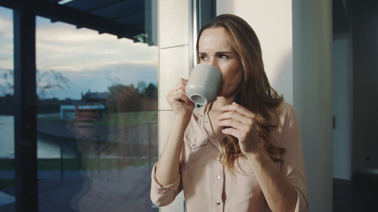 Mujer relajada soñando cerca de la ventana después de la jornada laboral. Mujer hermosa descansando.