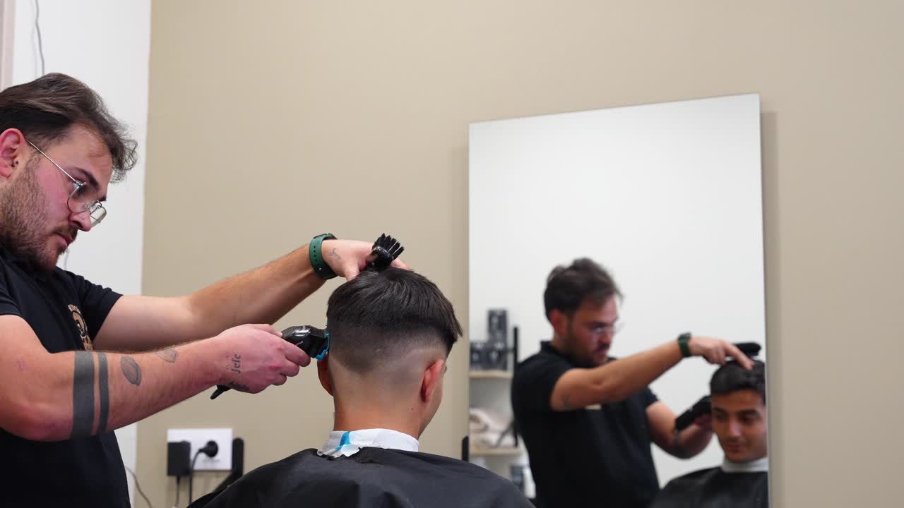 Bagfra: Frisør, der bruger trimmer på kunde under klipning i en barbersalon