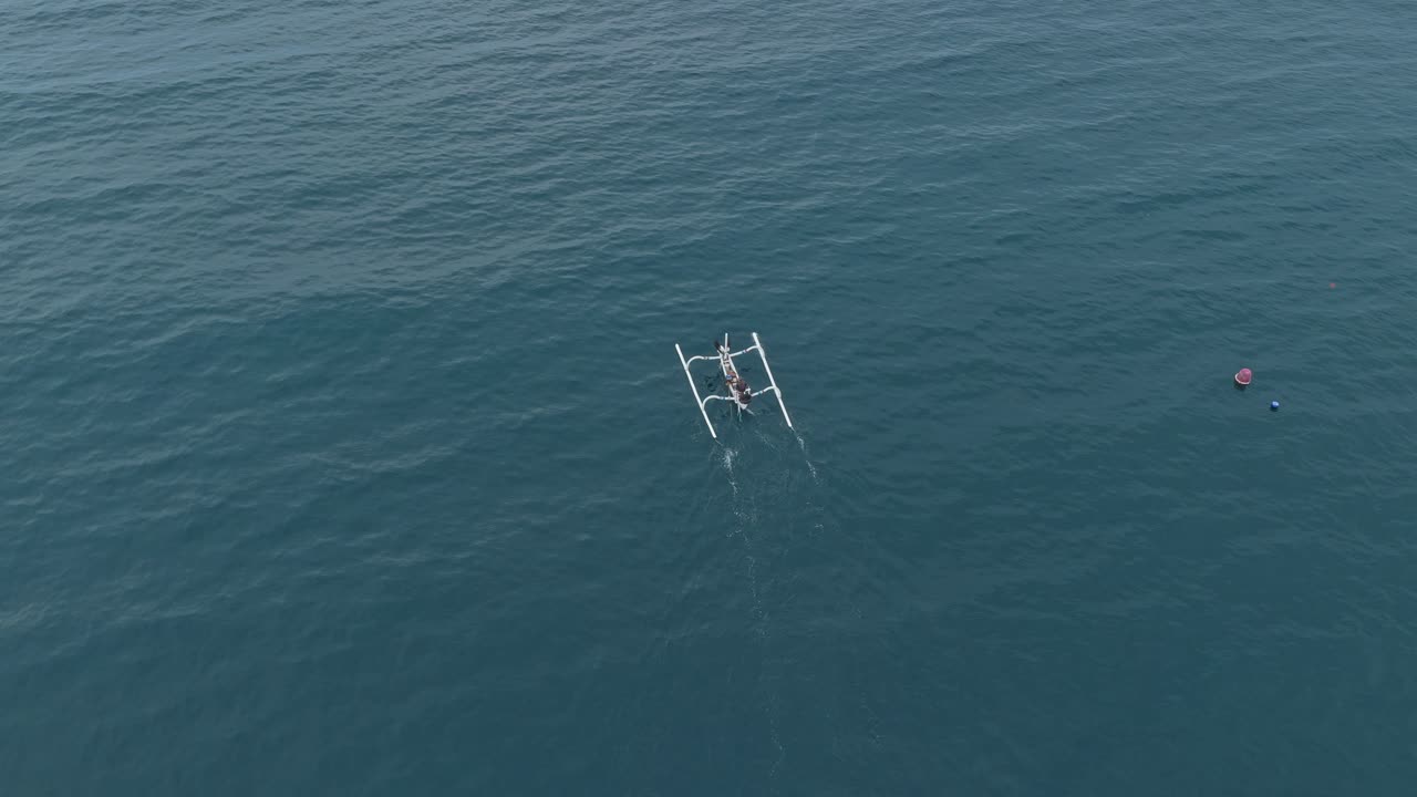 Tradisjonell balinesisk jukung-fiskebåt som seiler i havet