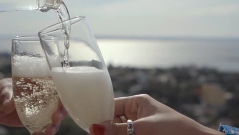 Pouring-sparkling-wine-into-a-glass-with-the-cityscape-and-river-in-the-background,-capturing-a-moment-of-celebration-and-the-scenic-beauty-of-the-city