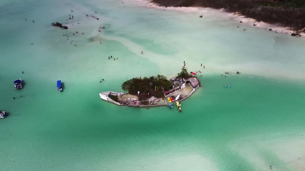 Pequeño islote en la laguna de Bacalar con playa tropical de arena, vista aérea del destino turístico en Quintana Roo, México.