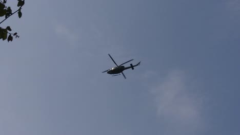 Cámara-Lenta-De-Un-Helicóptero-Flotando-En-El-Aire-Contra-Un-Fondo-De-Cielo-Azul