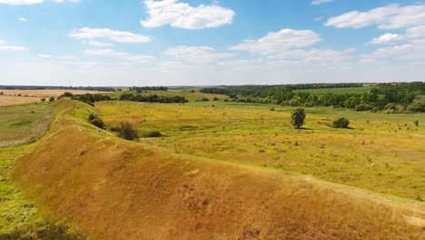 amazing nature landscape of trees and meadows. girl in white clothes going along the long hill in the meadow. beautiful summer day backdrop.