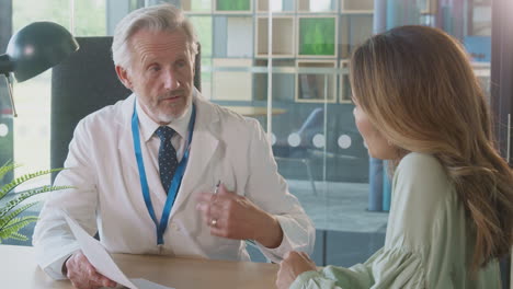 doctor at desk in office meeting to discuss test results with female patient in hospital