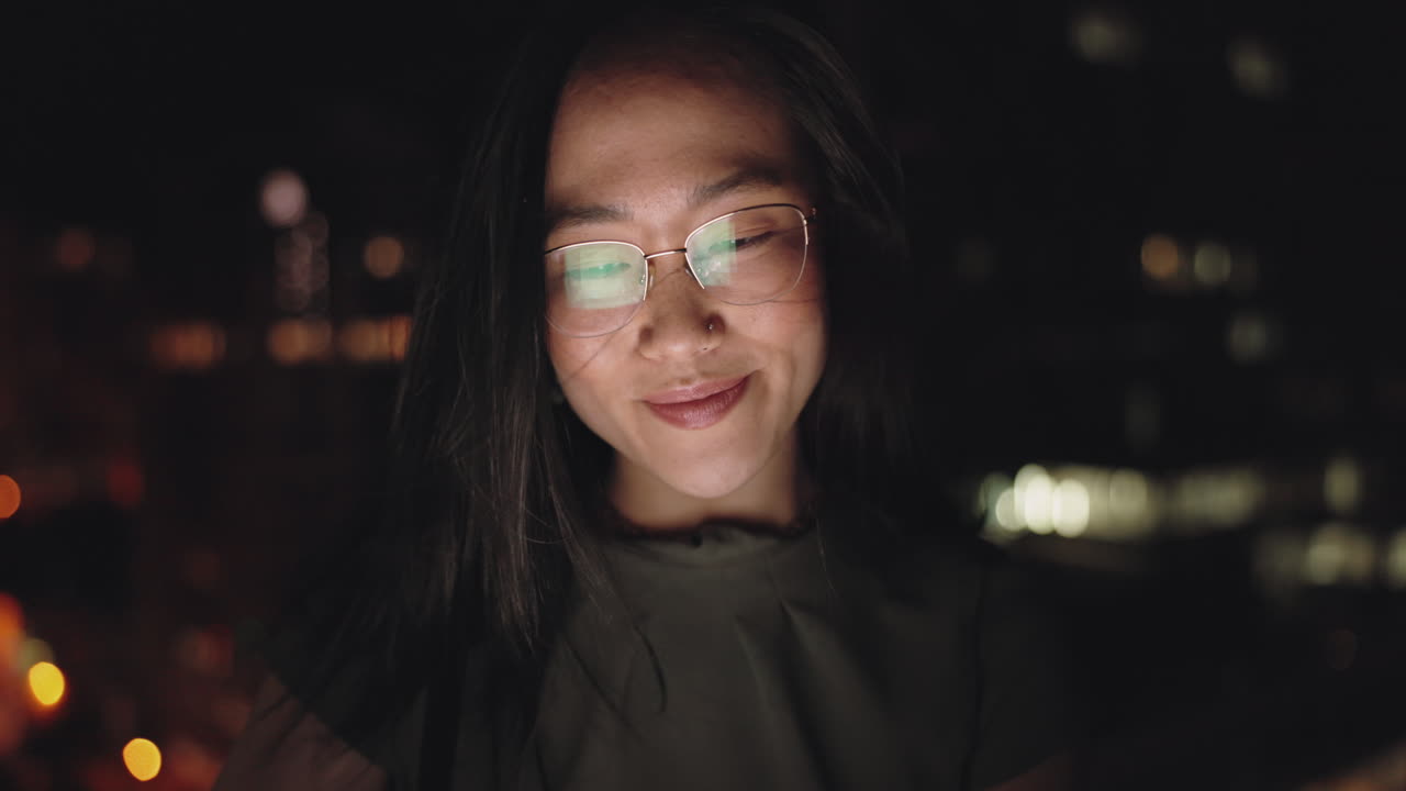 Woman using phone at night in city
