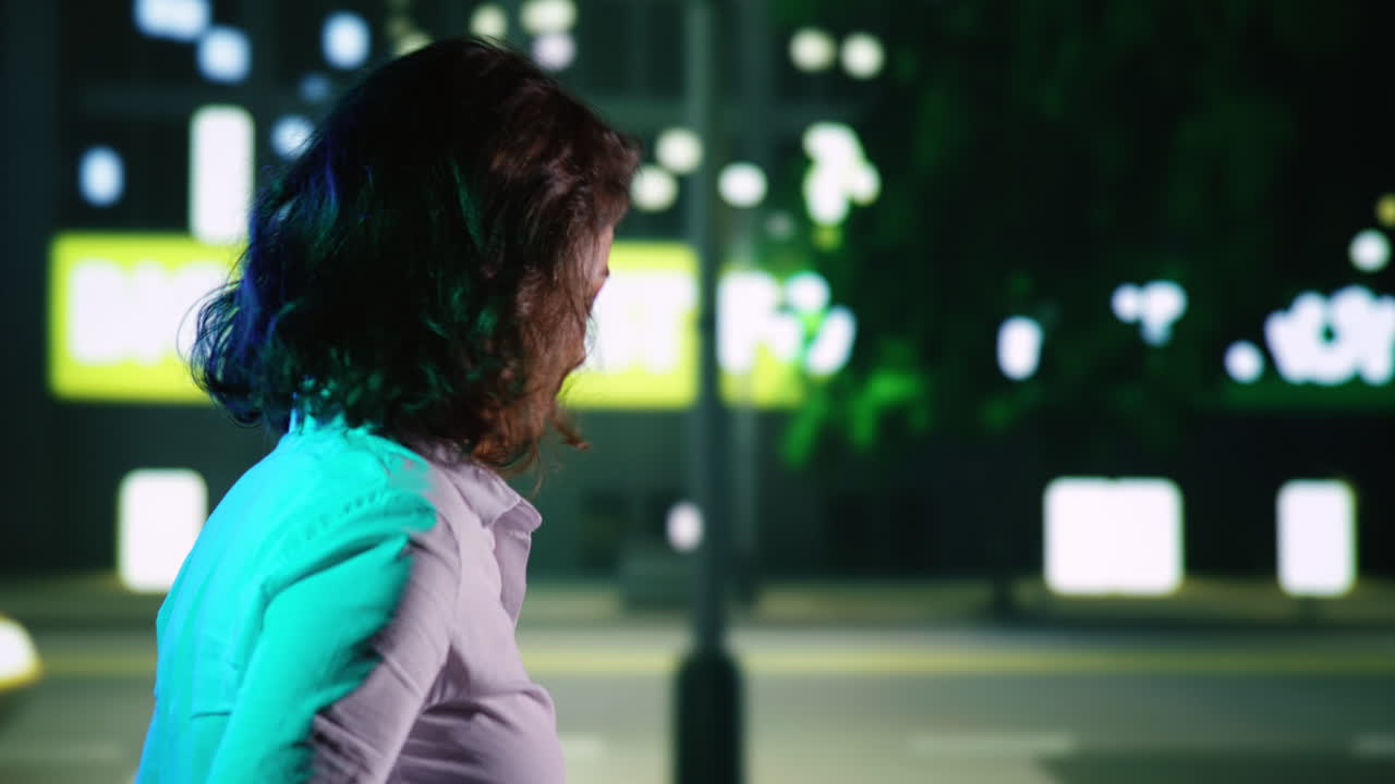 mujer caminando por la ciudad por la noche