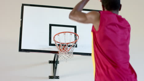 a middle-aged african american man is shooting a basketball