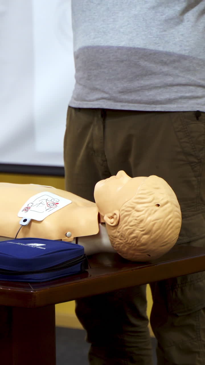 Training for safe life of child. Demonstrating chest compression on cardiopulmonary resuscitation baby doll. Vertical video