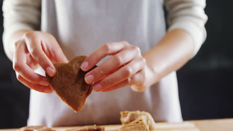 woman molding gingerbread dough on wooden board 4k