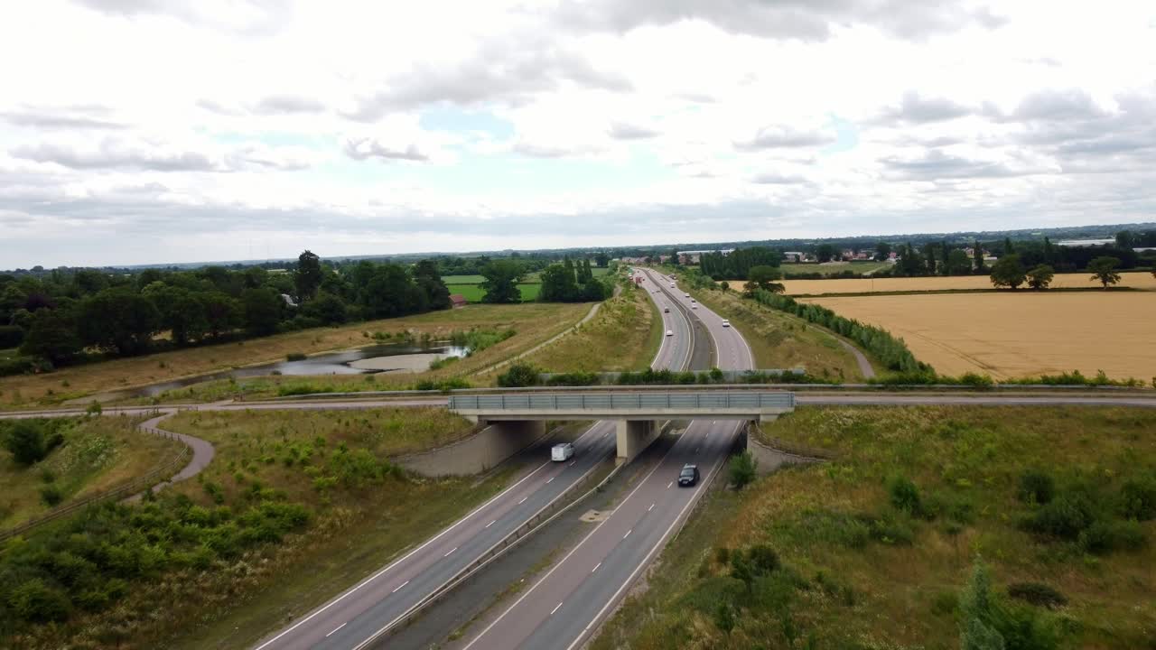 Aerial footage over Middle Road bridge over the NDR in Norfolk. Cars and other vehicles driving in each carriage way. Drone footages moves forward, slowly over the bridge