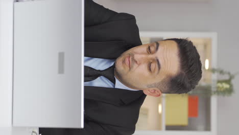 vertical video of home office worker man looking annoyed at camera.
